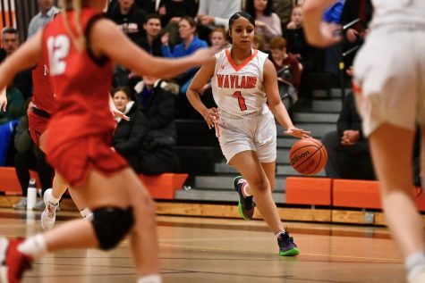 Senior Saniyyah Phillips dribbles the ball up to the three-point line. Phillips and senior captain Lila Powers were both named  Dual County League All-Stars. 