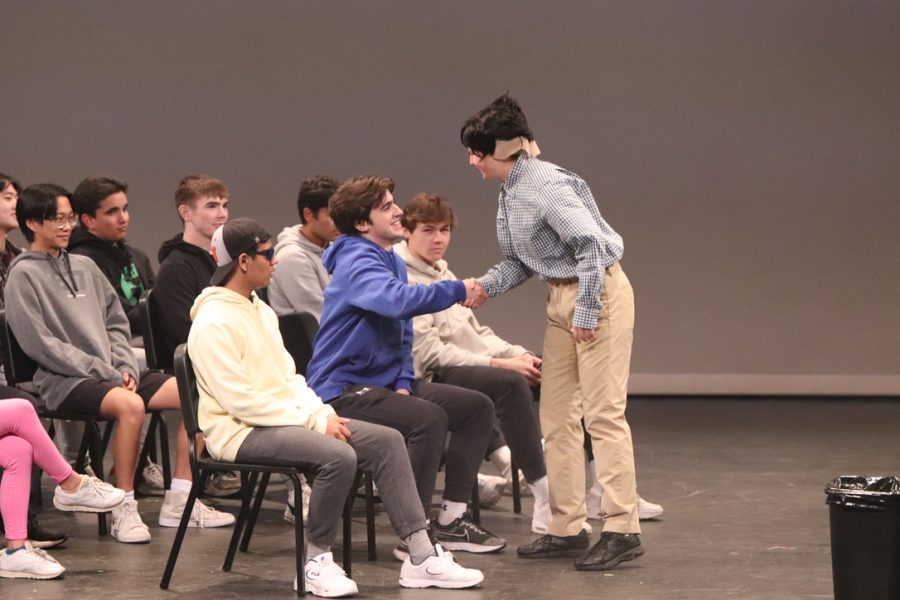 Senior Noah Malkin shakes hands with senior Grace Marto in the skit, Responsibility class. In the skit, Malkin played a student while Marto pretended to be a teacher.