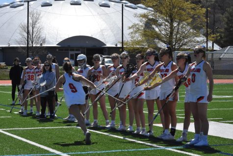 Sophomore Jillian Mele hits sticks with her teammates after getting her stick checked by the referee. Our team is very close this year, and I have many of my close friends on the team,  Mele said. It really does feel like a family.