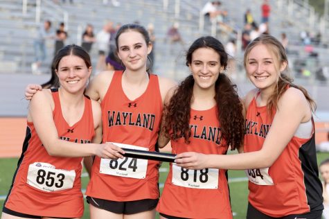 From left to right, freshman Katie White, sophomore Caitlin Heus-Smith, junior Anika Frutman and freshman Annie McQuilkin pose with the baton before their track meet. The WHS spring track team is made up of 115 athletes between the boys and girls teams this season.