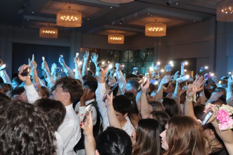 Students turn on their flashlights and wave their arms to the music during junior prom.