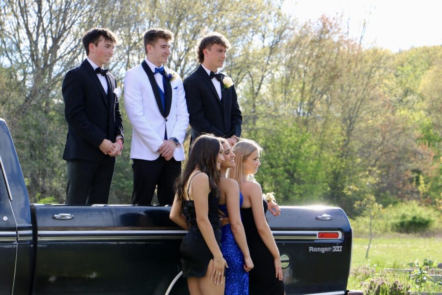 Senior Luke Caples, senior Jake Zocco and sophomore Alex Crawford stand in the trunk of the truck behind their dates, junior Gabriella Cannavino and seniors Ashley Hanna and Hannah Chase.