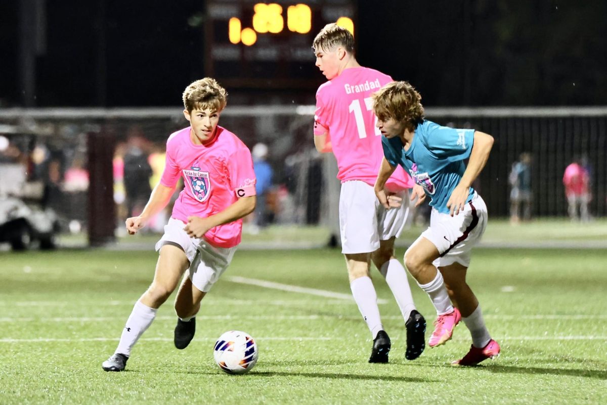 Captain senior Andrew Medeiros moves around a defender. The other captains of the boys varsity soccer team are seniors Zach Rainville and Jack Quinn.
