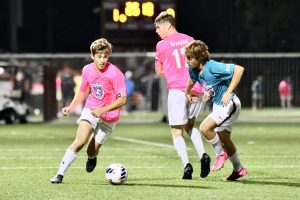 Captain senior Andrew Medeiros moves around a defender. The other captains of the boys varsity soccer team are seniors Zach Rainville and Jack Quinn.
