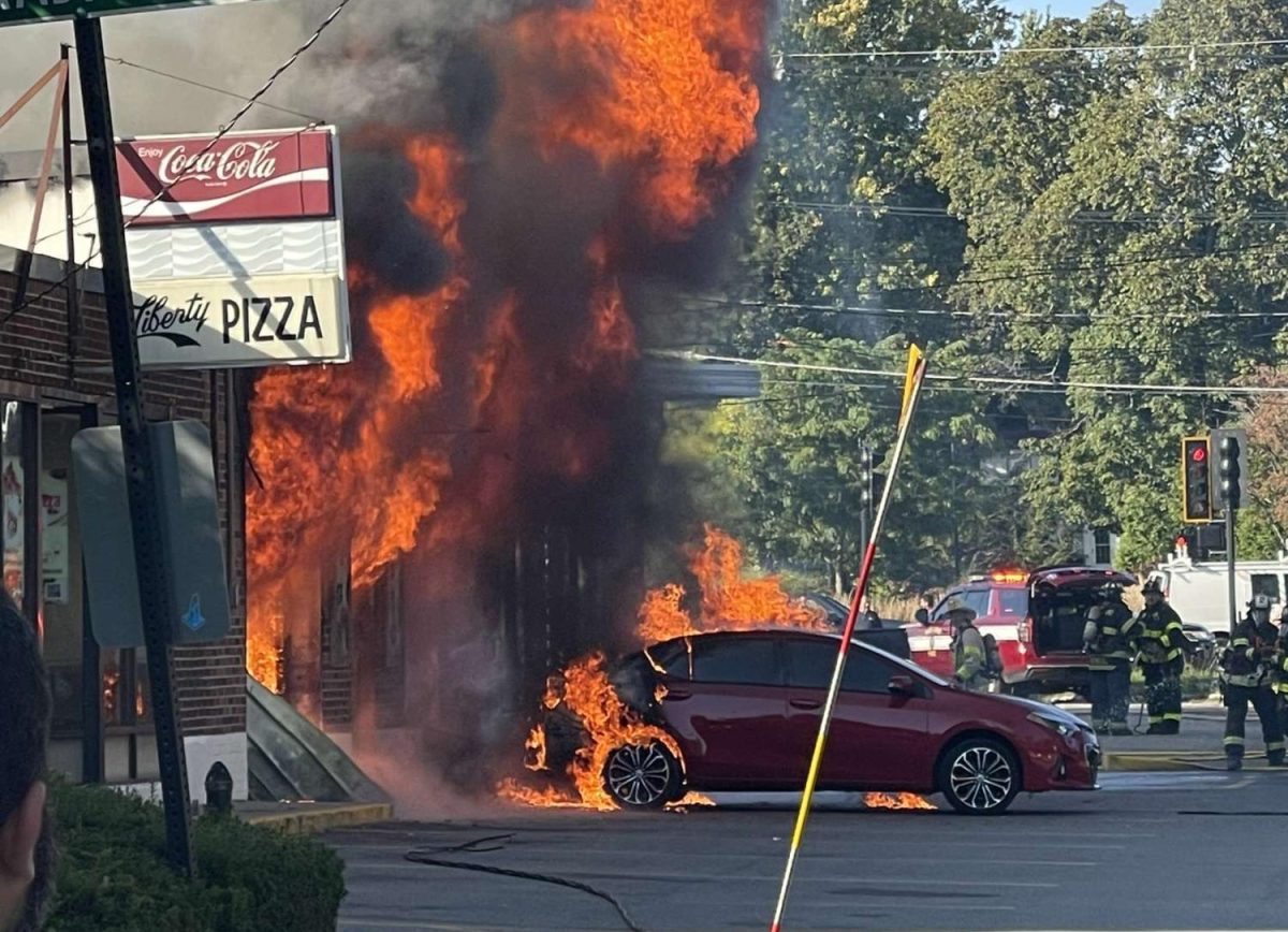 The fire reaches a car in front of the auto shop. Later on, the charred car was moved to allow firefighters better access to the fire. 