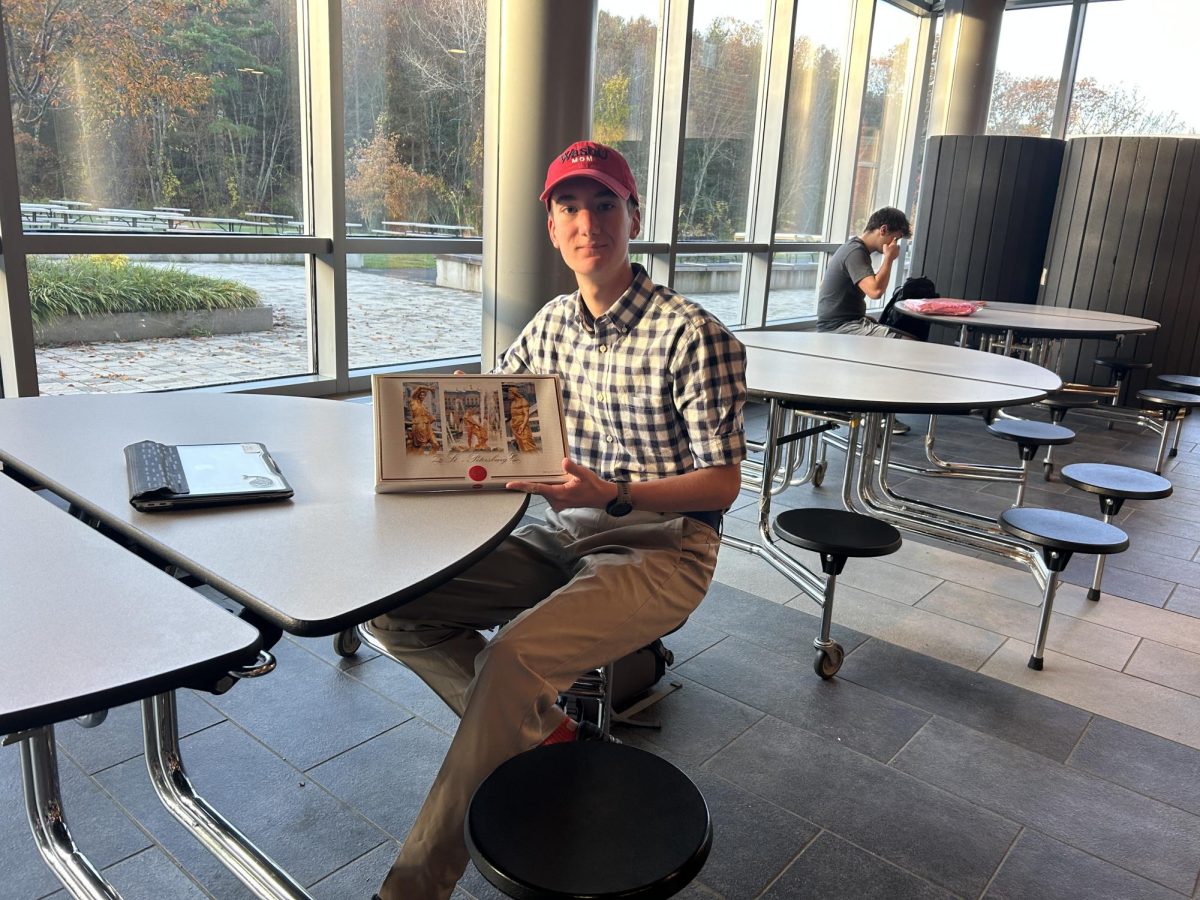 Senior Ben Cadoo poses with his book while dressed up as Forrest Gump.