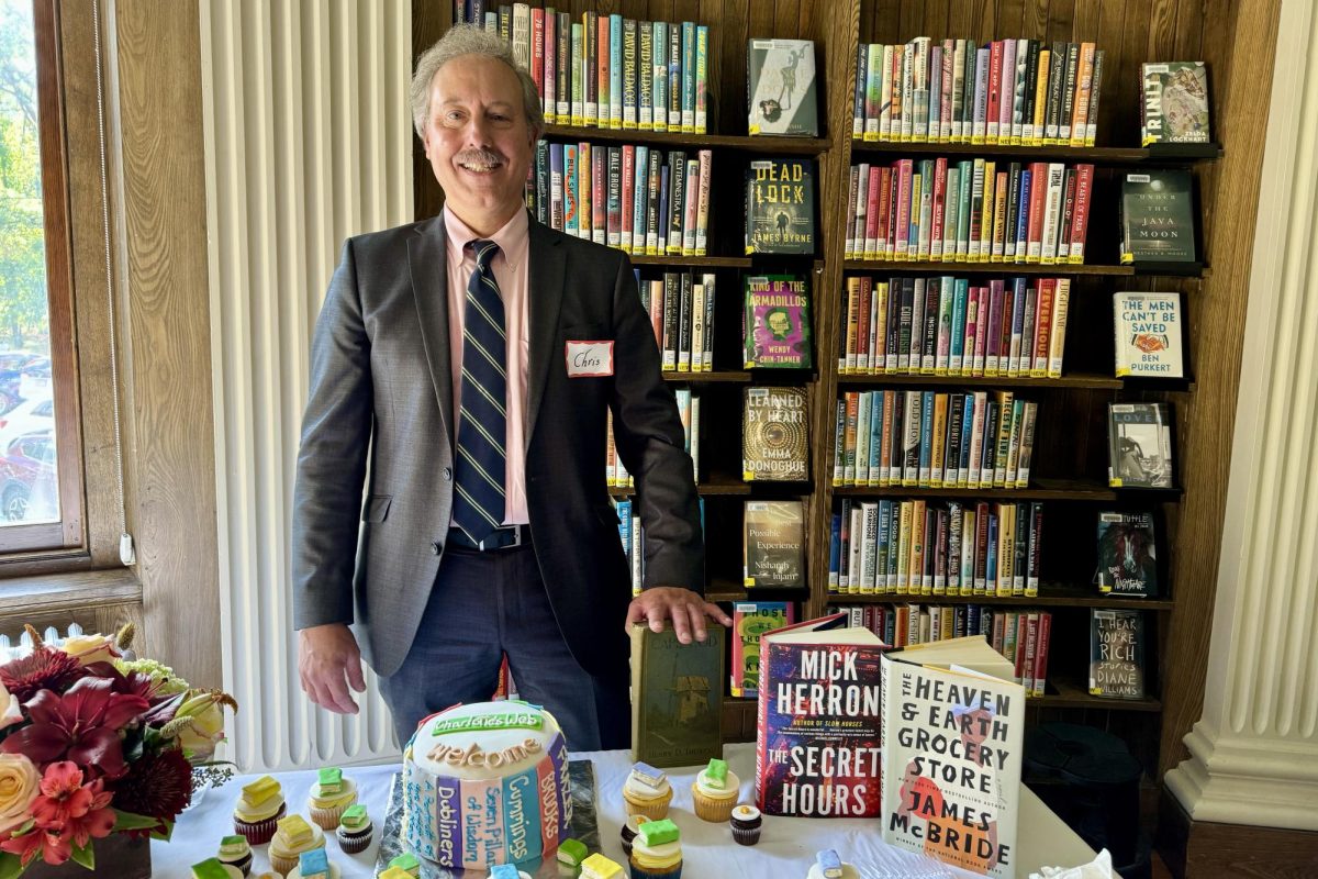New Wayland Free Public Library Director (WFPL) Chris Lindquist stands behind a table of book-themed treats at his welcome event to the WFPL community on Oct. 15. As the new director, Linquist aims to create a more inclusive library for the Wayland community.