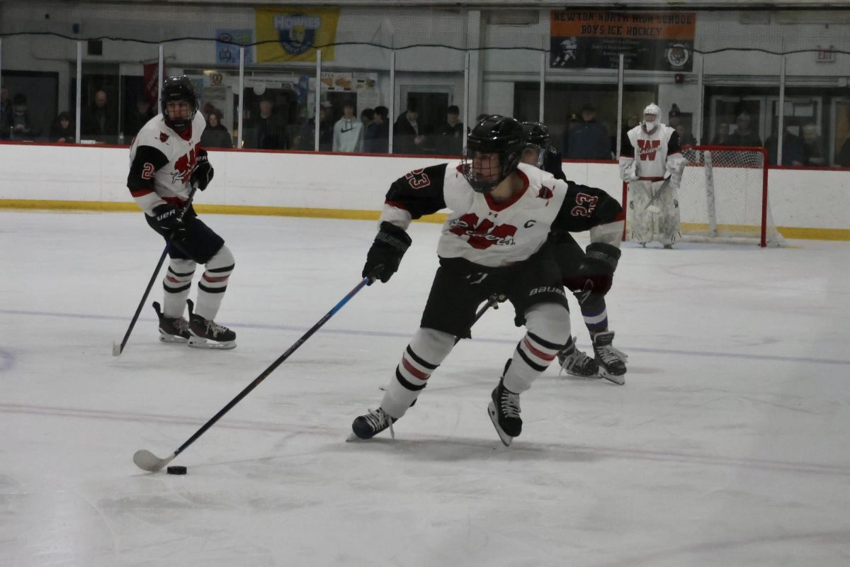 Senior captain Jack Ali moves up ice with the puck, shifting around opposing players.

