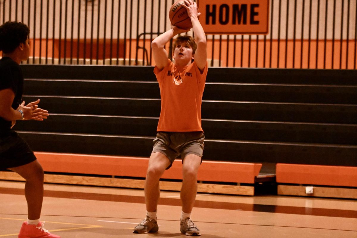 Senior orange team player Finn Surratt shoots the ball.