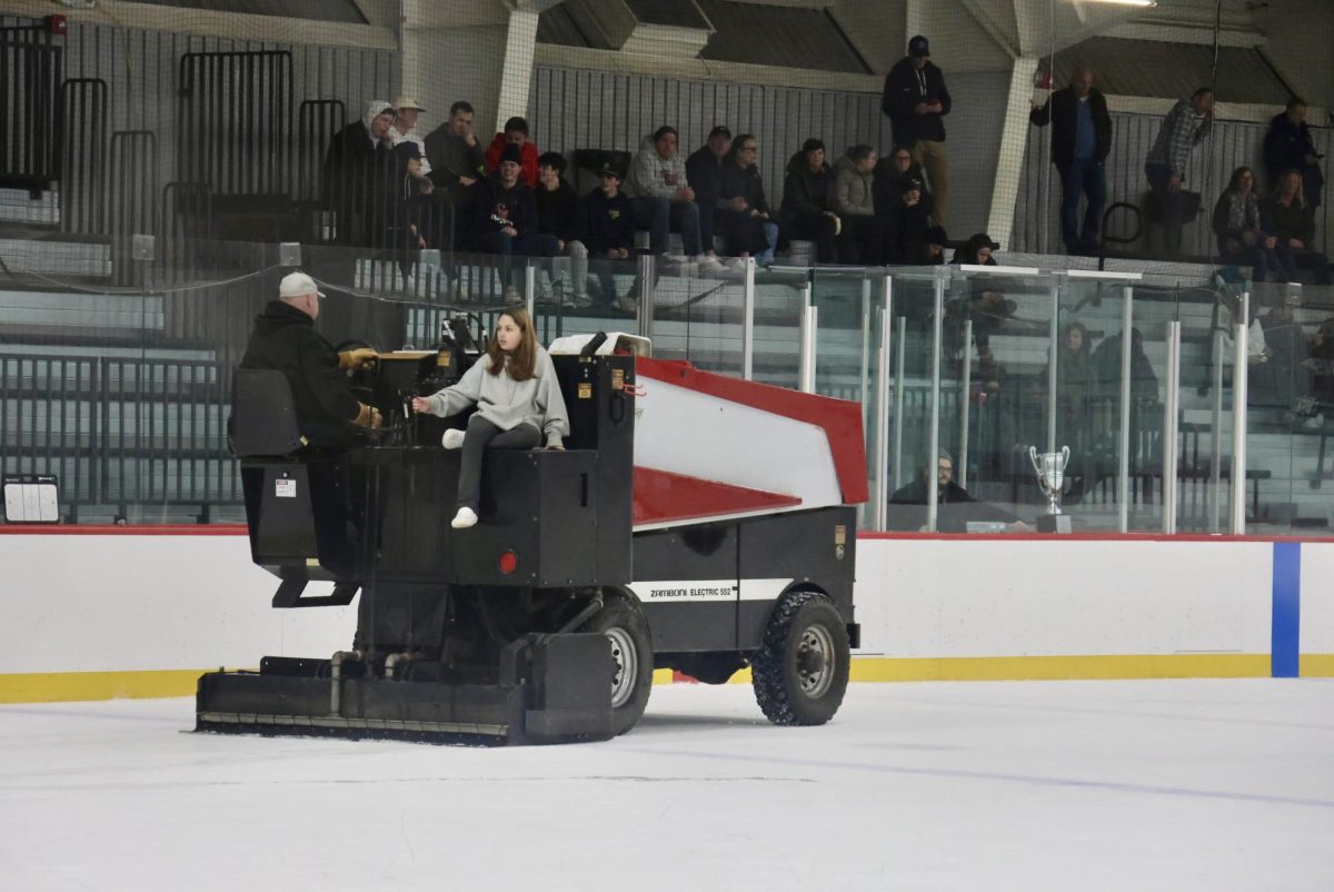 A fan gets to ride on the Zamboni while it is resurfacing the ice between the first and second period.