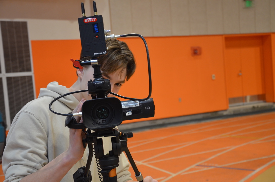 Freshman Eli McHugh films the game for the sports broadcasting class at WHS.