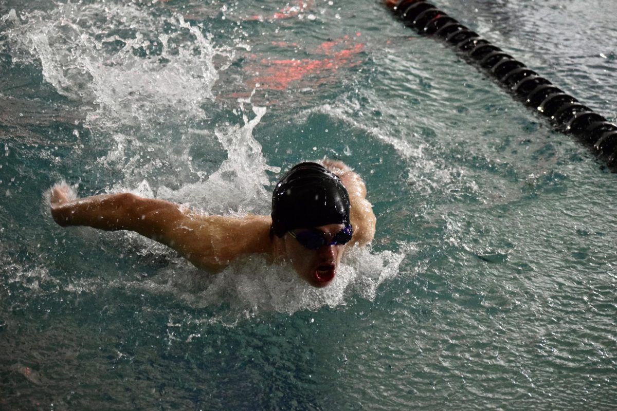 Junior Brady Foley catches a breath during the butterfly stroke midway through the race. Foley has been on the swim and dive team for three years. My favorite memory is probably having my whole team back me up and cheer me on when I swam at states last year, Foley said.