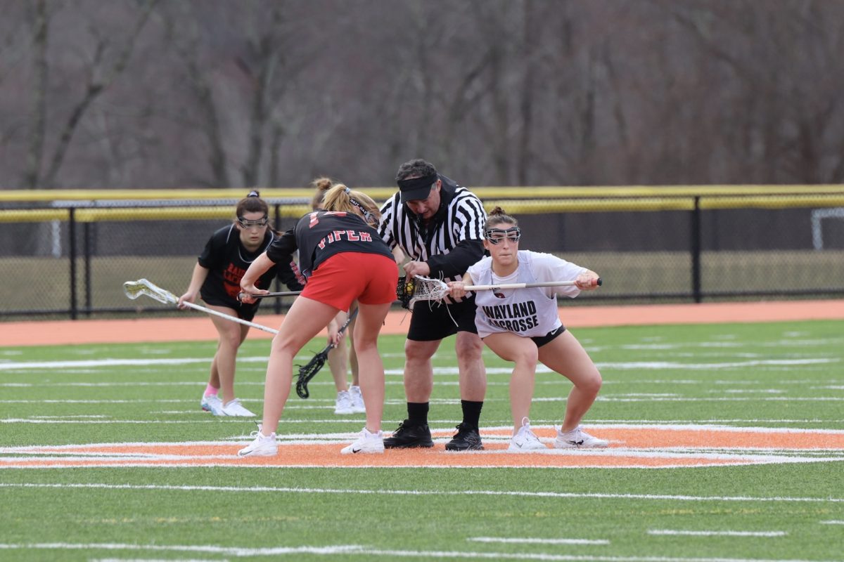 Junior Jillian Mele sets up for the draw. The draw takes place after each goal. During the draw, three midfielders from each team surround the circle while one from each team flicks the ball into the air to start the play.