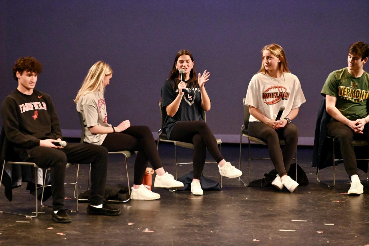 Senior Lilly ODriscoll talks into her microphone, alongside (from left to right) Zach Rainville, Hayley Shaw, Maggie Melander and Jack Ali. 