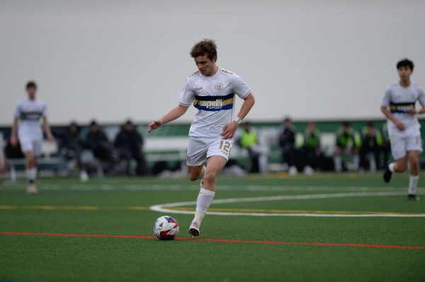 Junior Alex Crawford kicks the ball to a teammate while in the midst of running down the soccer field. After suffering an injury that nearly ended his career, Crawford got an offer from his club coach to play on the Major League Soccer (MLS) NEXT team. 