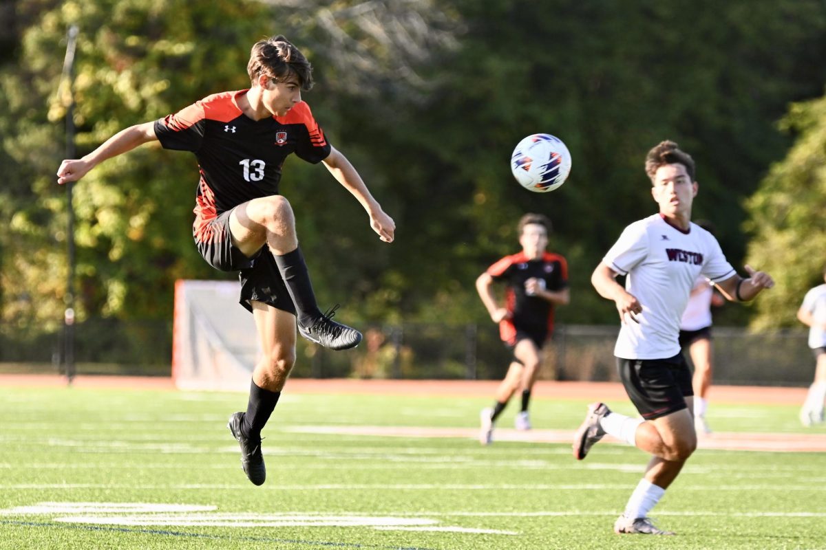 Junior Max Walsh rises and kicks the ball.