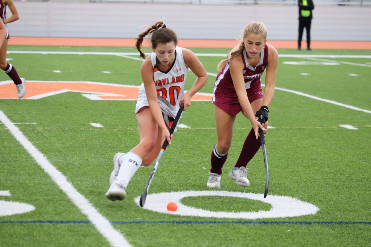 A Westford Academy player battles sophomore Melina Antun as she dribbles the ball.