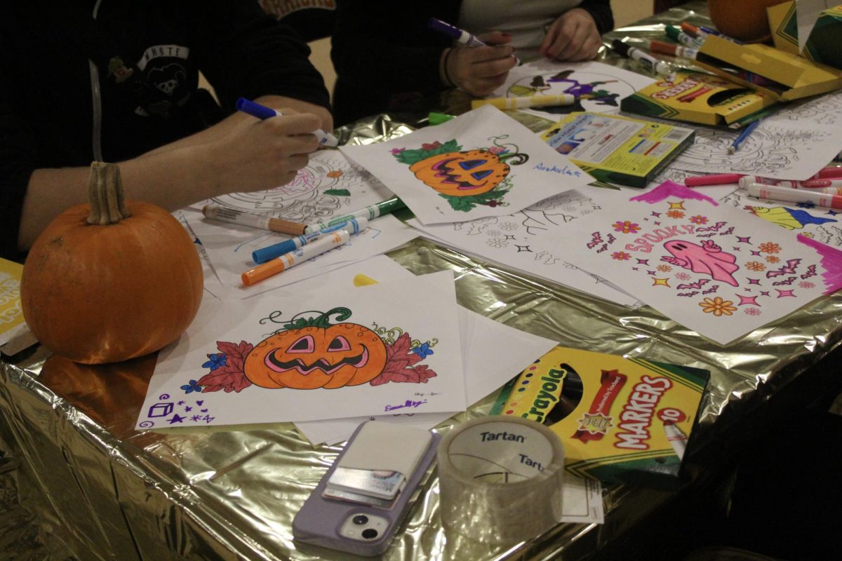 Halloween themed coloring sheets are laid out onto tables for people to decorate. "The fall festival went really well," senior Emma Alongi said. "I helped out at the coloring station for a while too."