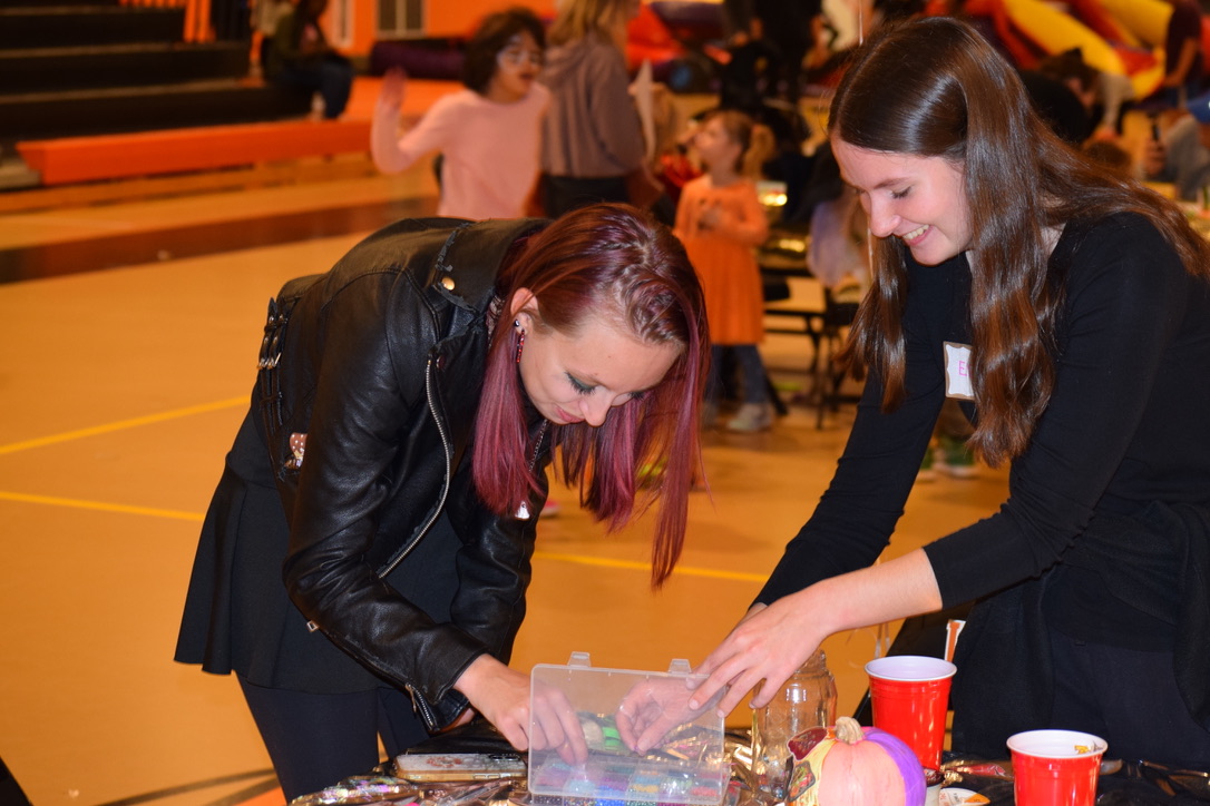 Seniors Rose Jaquinet and Eliza Cavalouzi organize one of the face painting tables. 