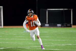 Senior Peyton Moran glances upfield after catching the ball from senior captain Michael Keenan.