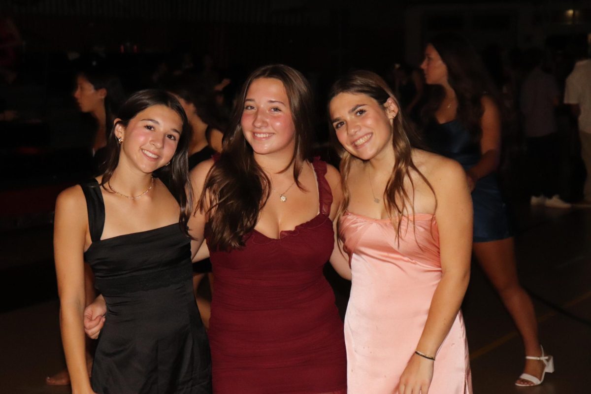 Posing for photo together, freshmen Abby Bergeron, Grace Zocco and Brooke Burgess take a break from the dance floor.