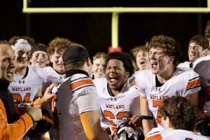 Junior Kordell Shouder and senior Jaden Kaufman yell in excitement as junior Michael Caulfield receives the 'Gladiator Helmet' represented to Wayland's player of the game, chosen by head coach Scott Parseghian after each game. 