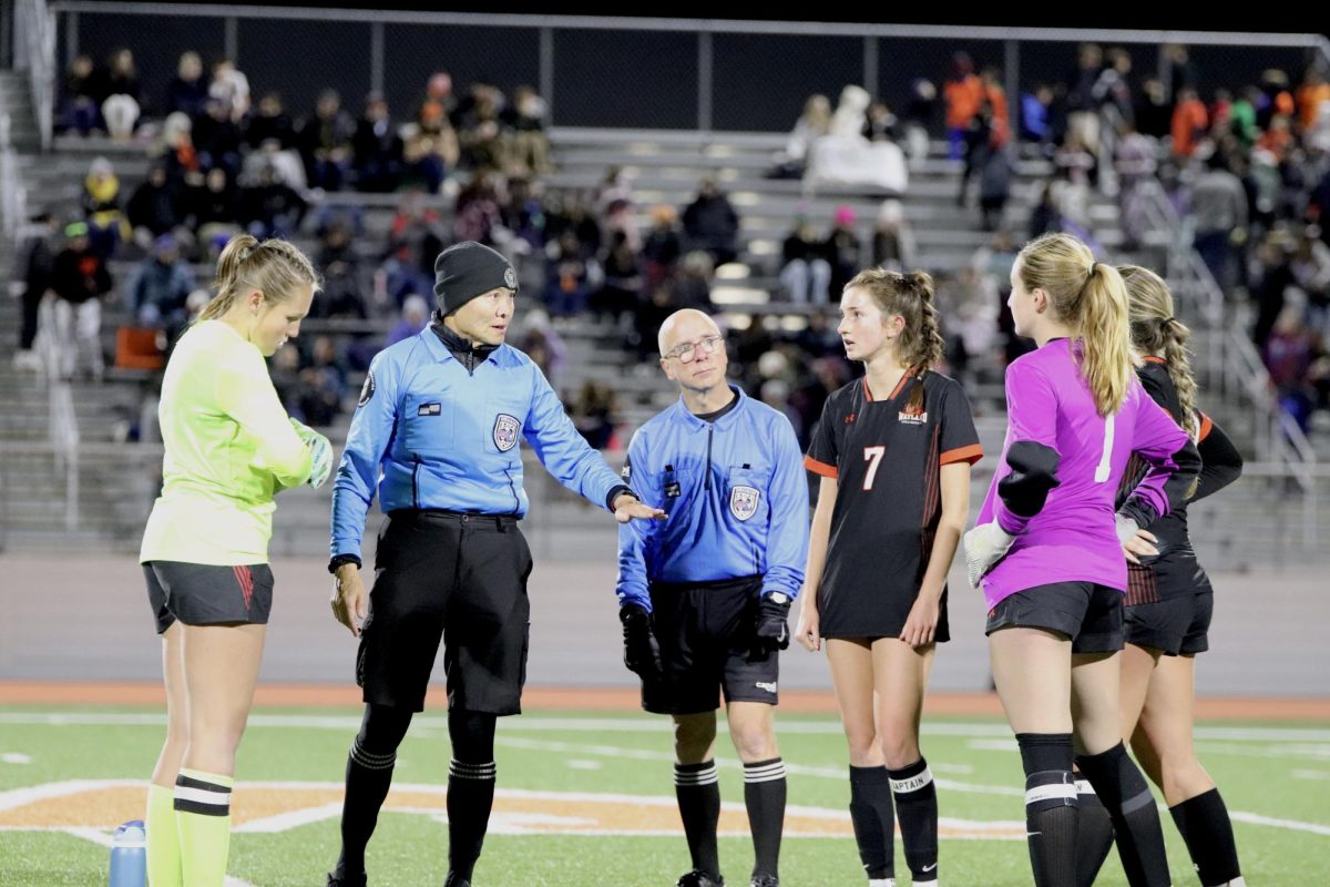 The captains from both Wayland and Westfield come together at the center of the field for a coin toss to determine who will start with the ball in overtime.