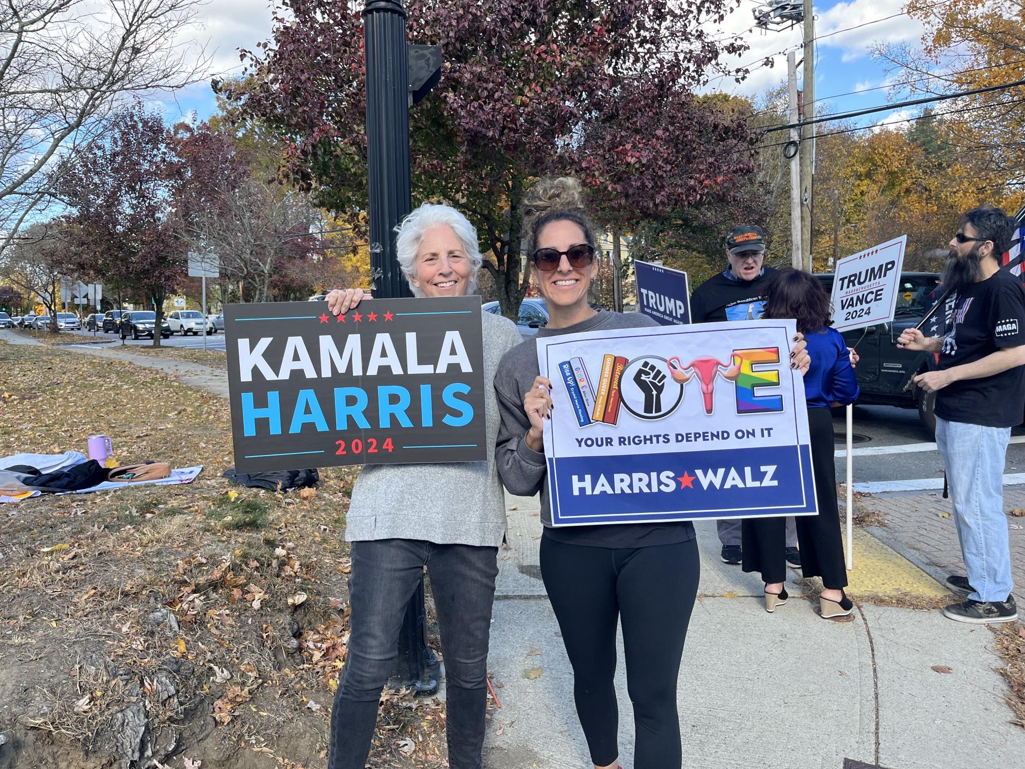 Harris supporter Jillian Kohl and her mother come together for a photo while Trump supporters stand in the background.