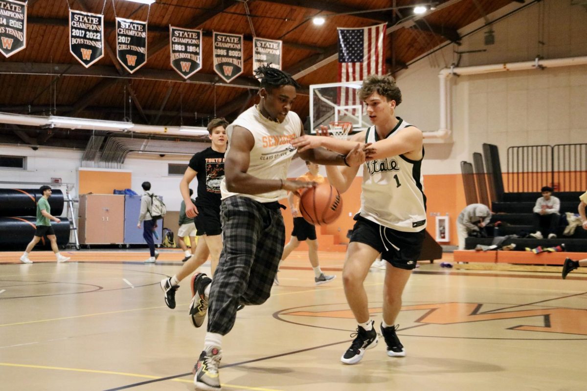 Senior Leroyal Harriston gets a rebound following a failed layup before dribbling the ball down the court. Orange team's record is 0-2 this season, but some players are maintaining hope to bounce back. "We've had some tough games but it's nothing we can't come back from," senior Felix Kissell said.