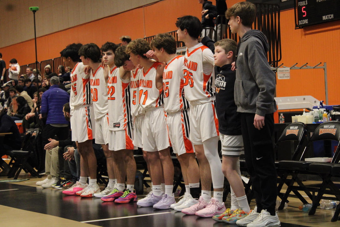 Some Wayland players on the bench stand side by side during the last moments of the game. 