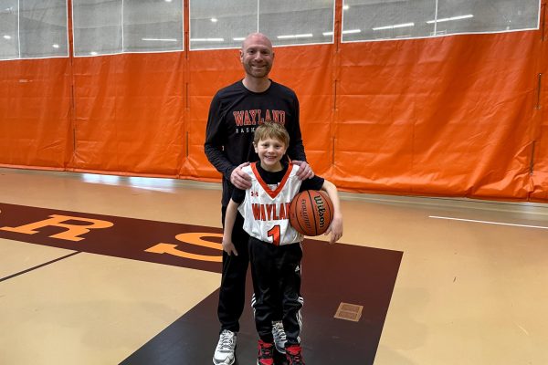 New girls varsity basketball coach Stephen Marks stands with his son after being a referee for a Wayland alumni players versus current players game. 