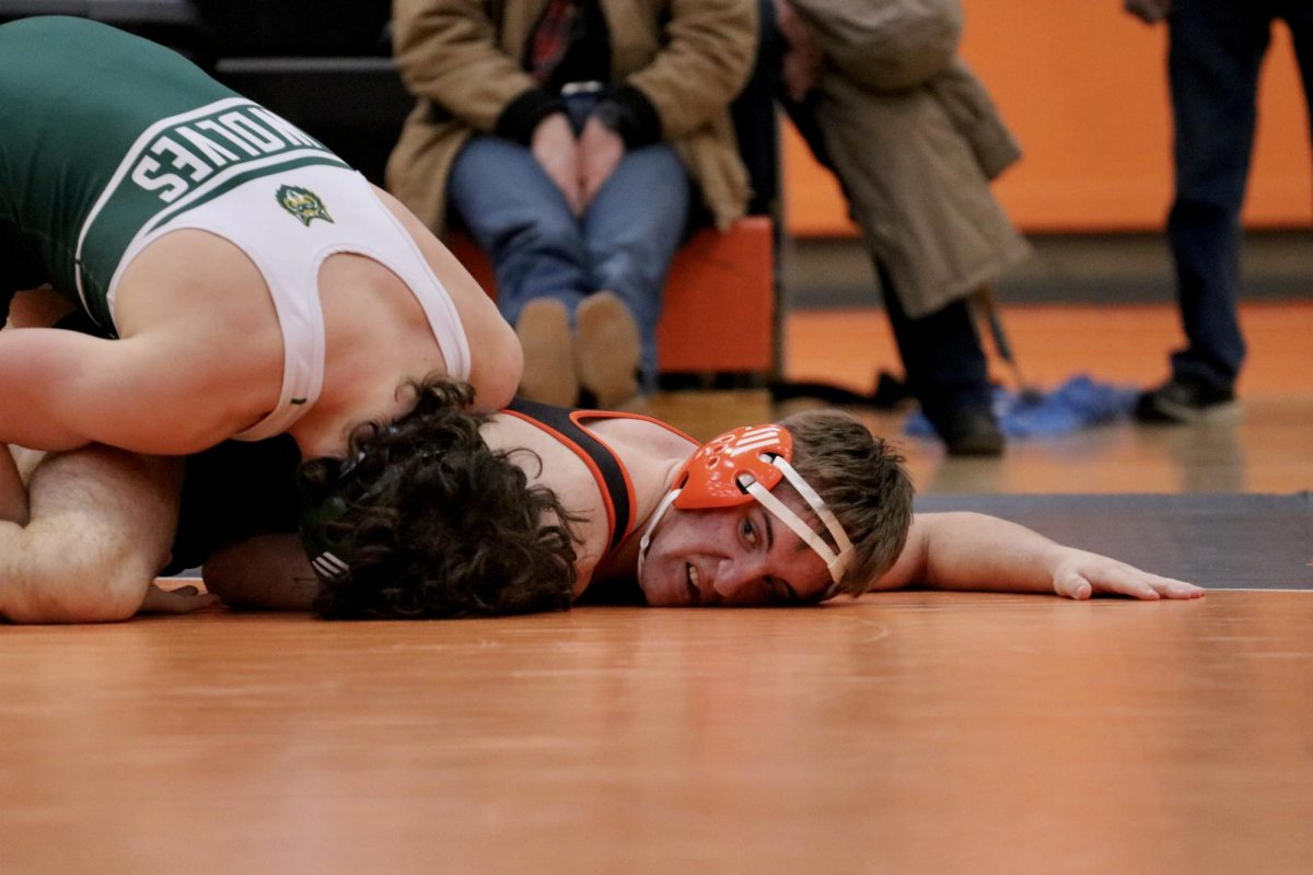 As his opponent grabs onto one of his legs, senior Anthony Brown gets stuck underneath.