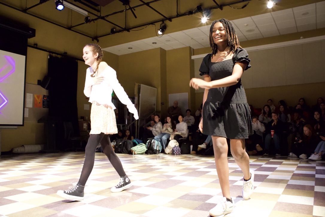 Sophomores Molly Cavalluzzi and Ryan Harding laugh as they model their fully thrifted outfits. The goal of Green Team's fashion show was to share benefits of reusing clothing and encourage others to not have an entire closet of new closet.