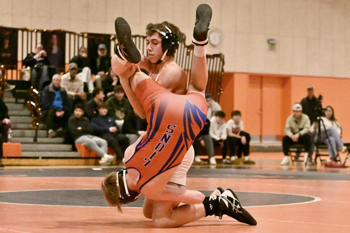 A Wayland wrestler and a Newton-South wrestler face off on the mat during the DCL championship clinching meet on Wednesday, Feb. 5. 