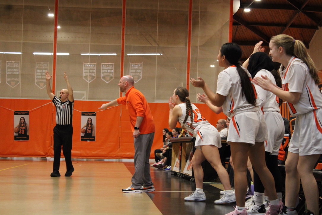 After an exciting basket, Wayland players on the bench shot up to cheer for their teammates. Head Coach Stephen Marks directed his players where to go on the court in order to successfully defend the other team.