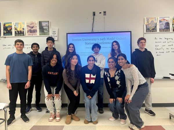 The Model UN club poses for a photo during their weekly Tuesday meeting. Pictured on the screen behind them is the website for their upcoming conference in Boston. 