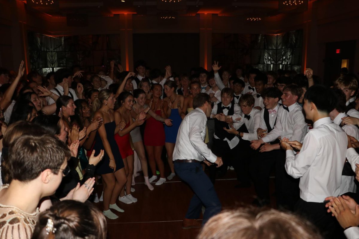 Prom attendees form a circle around history teacher Timothy Glavin.