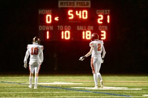 Two players from the Class of 2025 walk towards the score board, before the next play.