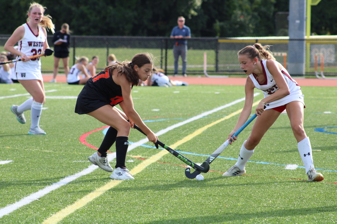 Freshman Ella Berenson battles a Weston player for possession of the ball at midfield.