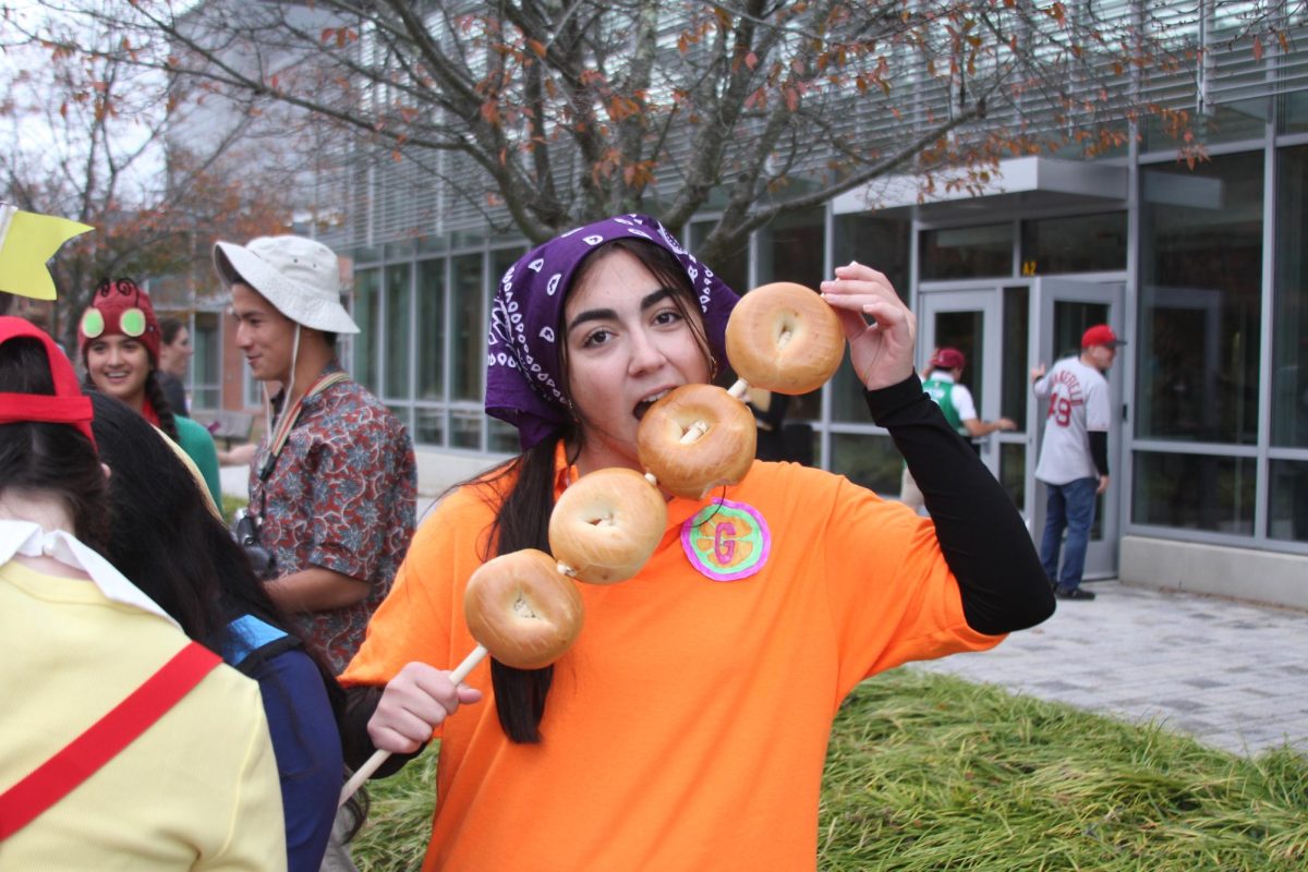 Senior Sona Abrahamyan dresses up as T-Bo from "iCarly," completing the costume with four bagels on a stick.