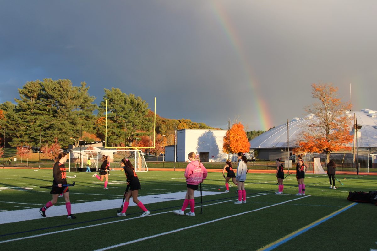 Warming up for the game, the team practices their stick skills in front of a rainbow. This field hockey season, the team has won four games, tying twice and losing 12 games.
