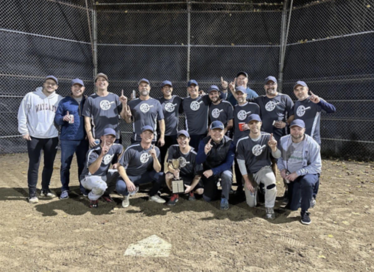 The Ye Old Master Batters pose for a photo, pointing their fingers in the air after winning the playoffs.