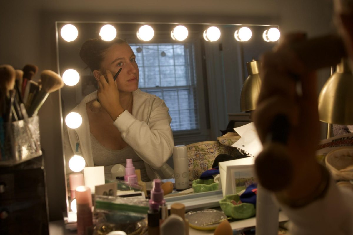 After she eats her breakfast, senior Annie Melander throws on some makeup for her dress rehearsal. 
