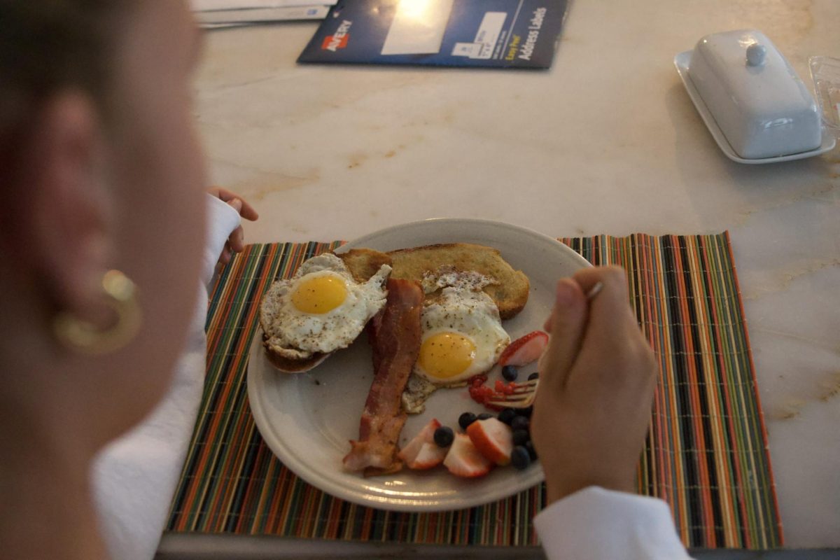 Starting her day off right, senior Annie Melander eats a breakfast made by her parents. 