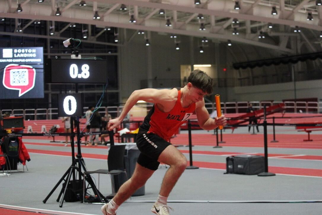 Senior Captain Ryan McCormack sprints in a relay. McCormack enters the season with energy, having just recently committed to Boston University's Division I track team.