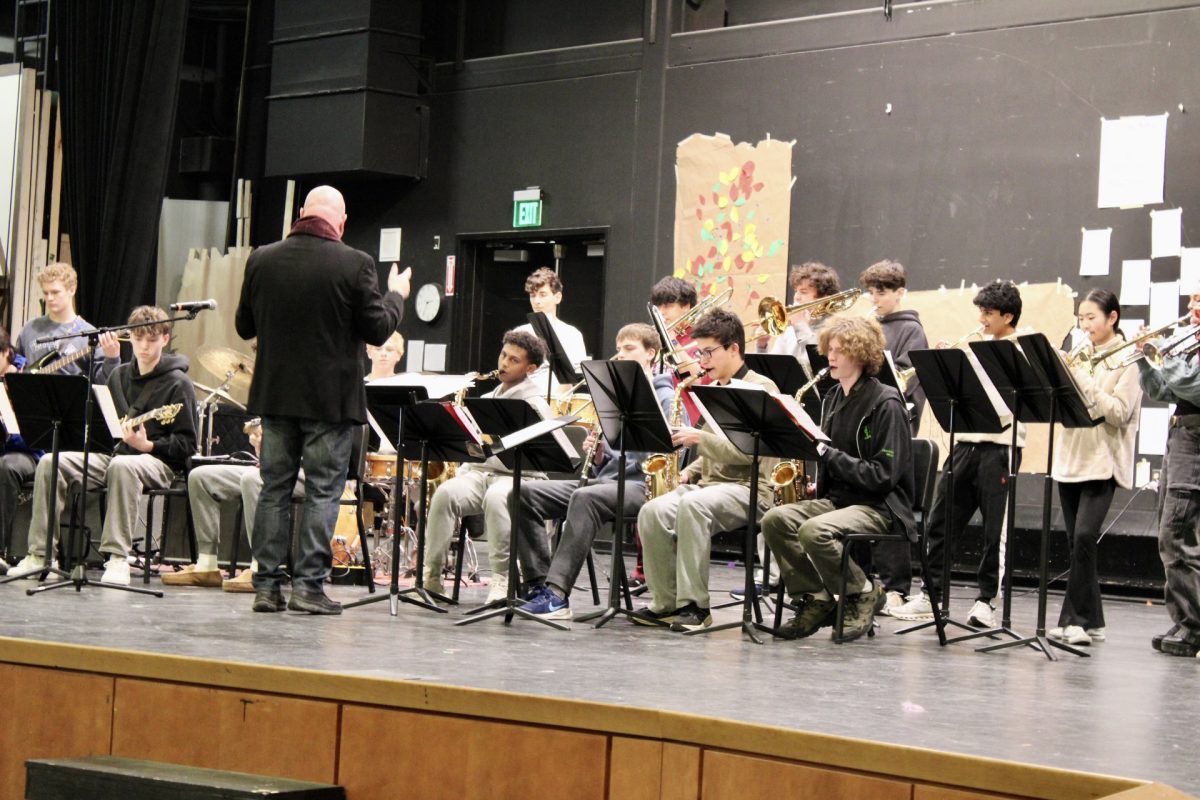WHS Jazz Ensemble Band Director Joseph Oneschuk conducts the ensemble while performing a latin song. During the performance, Oneschuk gave the audience a choice between a funk song and a latin song. The audience chose the funk song.