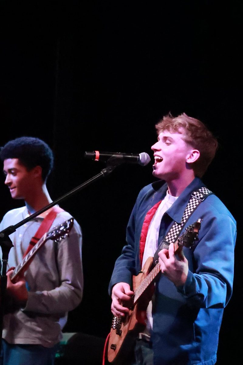 Senior Atticus DeGrenier smiles while belting out to the audience. DeGrenier has played violin since third grade, inspired by senior Sebastian Chung. However, when reaching high school, he started playing the bass and guitar. "I wanted something different," DeGrenier said. "I wanted to play the music that I actually liked."