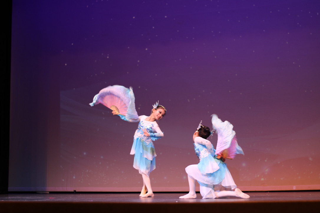 Artisan Dance Academy members Clarice Le and Zoe Rao wave their fans and smile as they perform "Dancing Fins."