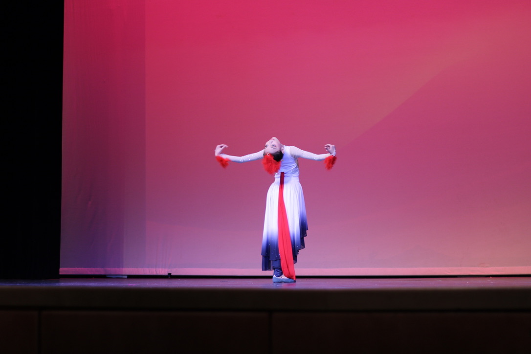 Angel Performing Arts member Charlotte Yu leans back to face the audience as she performs her dance titled "The Soaring Crane."