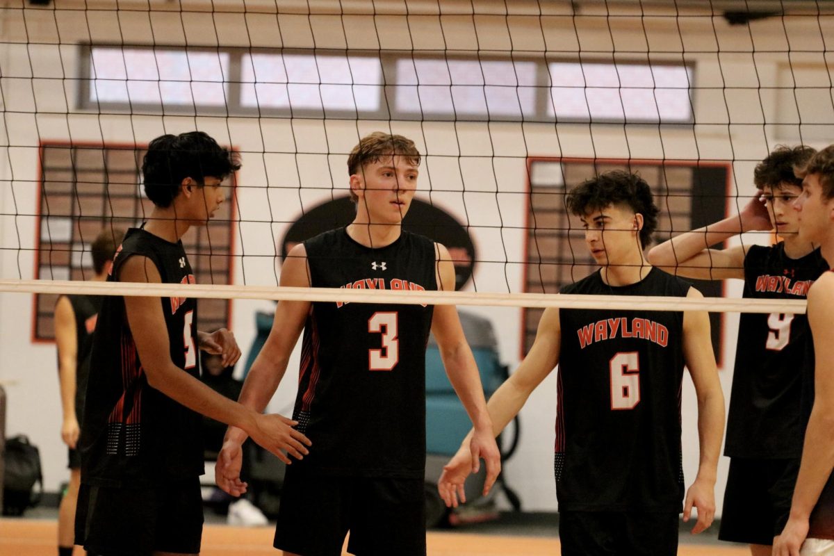 Setting up to receive a serve from the other team, from left to right, junior Varun Bhukhanwala, senior captain Finn Bell and senior Max Walsh high five before going to their places on the court.